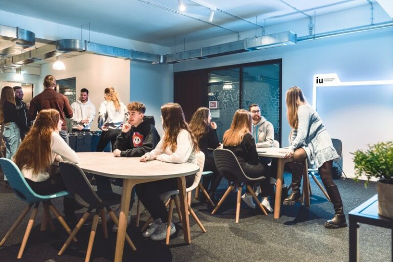 Studierende an der IU Internationale Hochschule im Austausch – Symbolbild für das duale Studium bei UNIPLUS.